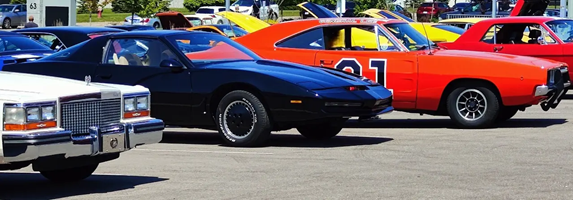 Side-by-side display of the 1982 KITT replica and the General Lee, celebrating two of the most iconic TV cars of the 1980s.